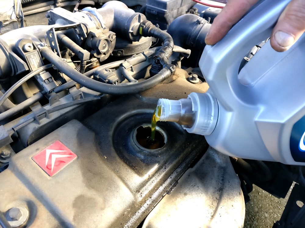 Vertiendo aceite nuevo en el motor de un carro